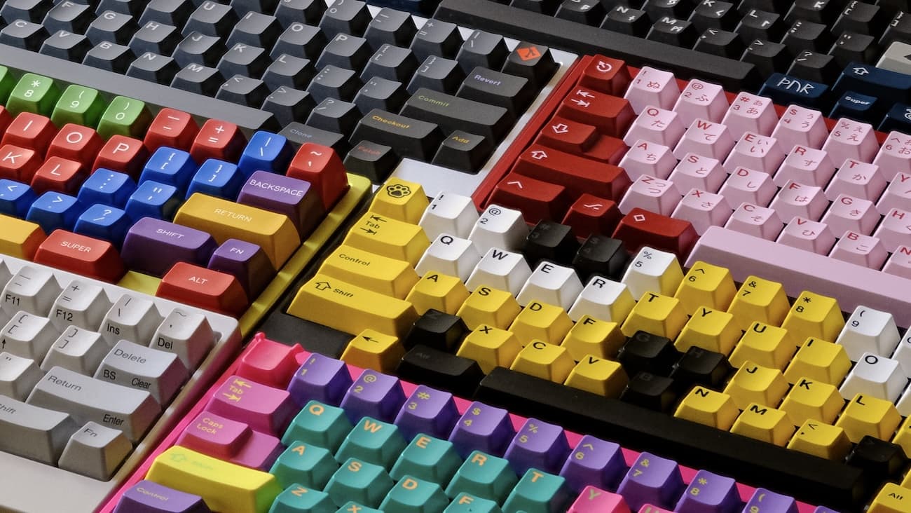 Spread of multi-colored mechanical keyboards with vibrant custom keycaps