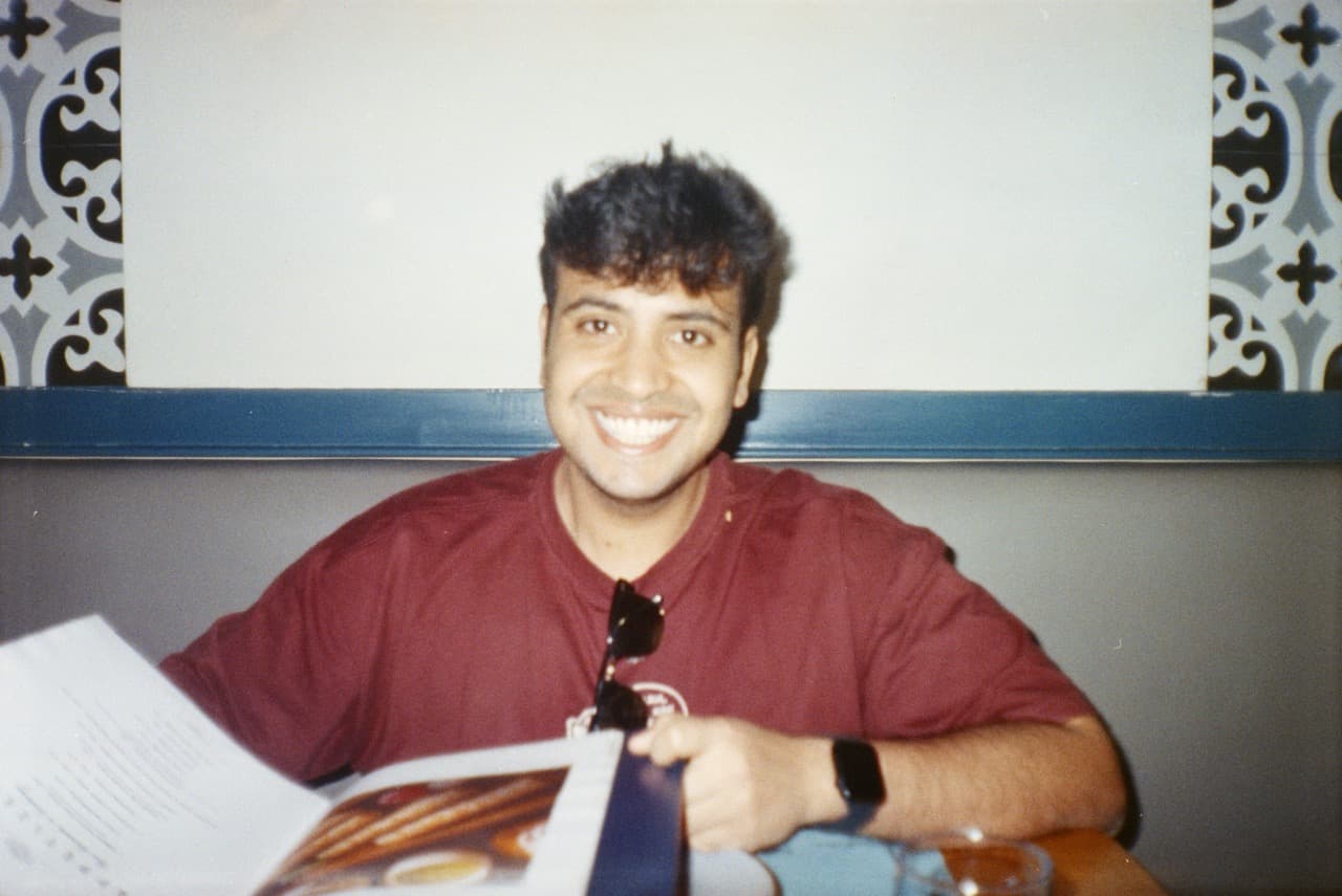 Man in maroon shirt at desk in vintage film photo