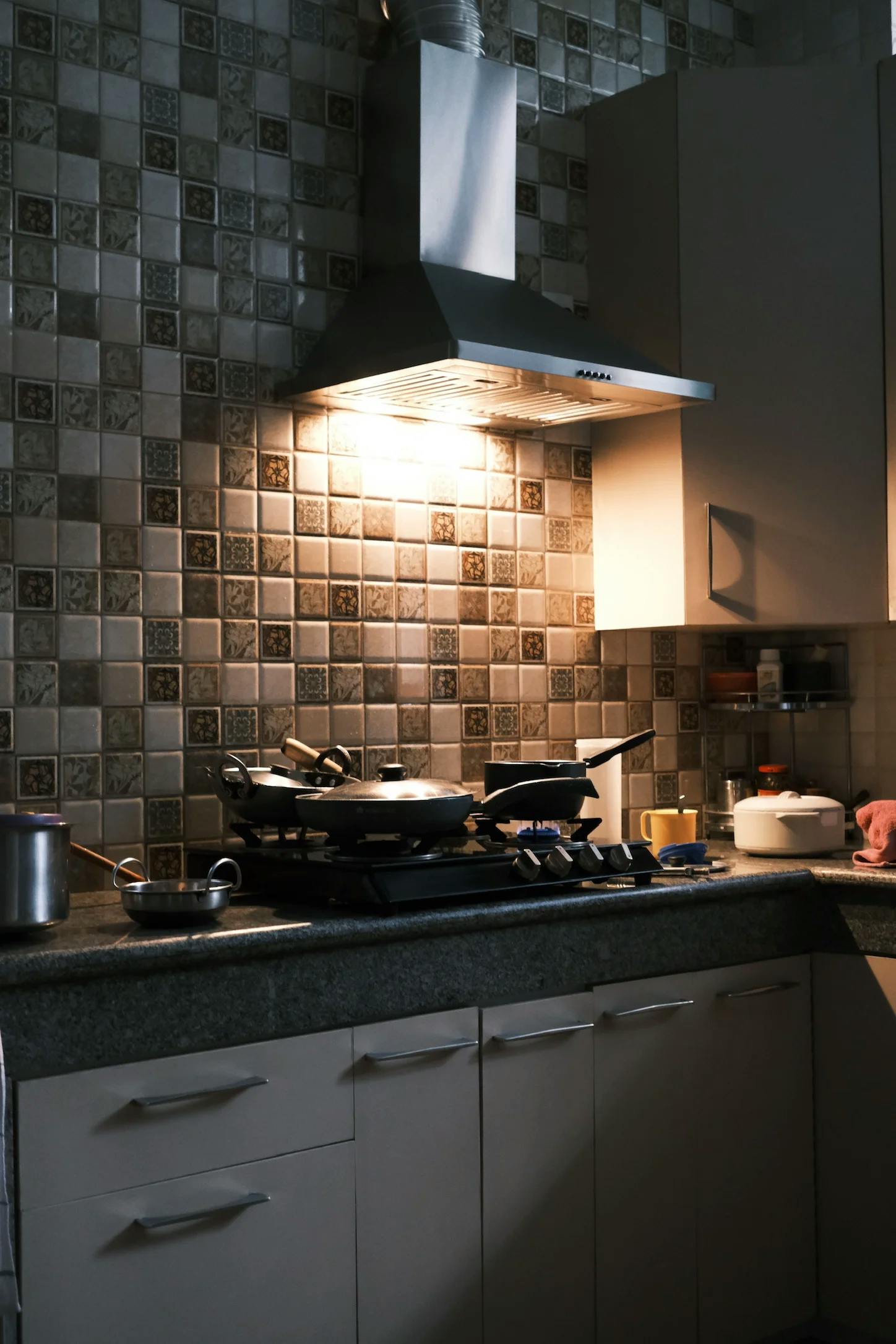 A stovetop with warm light coming from the exhaust.
