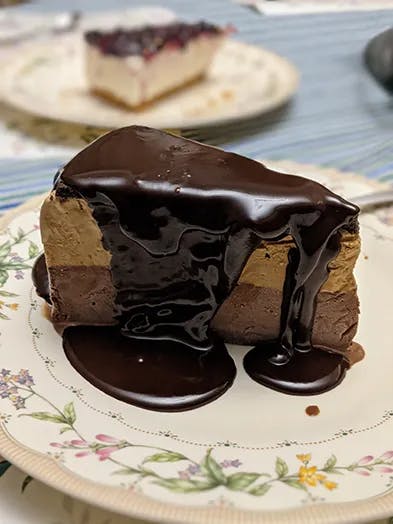 I large piece of mud pie with chocolate sauce dripping down its sides